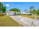Charming single-story home with a well-manicured lawn, white exterior, and RV parked in the driveway at 9086 Enchantment Dr, Largo, FL 33773