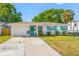 Inviting home exterior with a turquoise front door, matching shutters, and a well-kept yard at 9086 Enchantment Dr, Largo, FL 33773