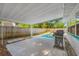 Covered patio area overlooking a sparkling pool, providing shade and relaxation in the backyard at 9086 Enchantment Dr, Largo, FL 33773