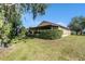 Expansive backyard with a lush lawn, privacy hedges, and a covered screened patio at 7519 Berna Ln, Land O Lakes, FL 34637
