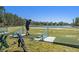 Driving range with water view and golfer, showcasing mats, netting and golf bag on a sunny day at 7519 Berna Ln, Land O Lakes, FL 34637