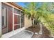 Screened-in front porch with a red door, complemented by lush landscaping and a stone pathway at 7519 Berna Ln, Land O Lakes, FL 34637