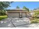 Beige two-car garage with a wide driveway and decorative doors, located in a sunny, landscaped neighborhood at 7519 Berna Ln, Land O Lakes, FL 34637