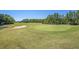 Expansive golf course with a green and sand trap surrounded by trees and lush green grass at 7519 Berna Ln, Land O Lakes, FL 34637