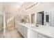 Bright main bathroom featuring a dual sink vanity, walk-in shower, and tile floors at 7519 Berna Ln, Land O Lakes, FL 34637