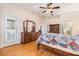 Main bedroom with wood floors, ensuite bath and a large dresser with mirror at 7519 Berna Ln, Land O Lakes, FL 34637