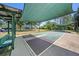 Outdoor shuffleboard courts with seating, under sunshades, with landscaping, trees, and green space at 7519 Berna Ln, Land O Lakes, FL 34637