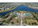 Aerial view featuring the community clubhouse, pools, and meticulously landscaped areas by the serene lake at 10005 Sage Creek Dr, Ruskin, FL 33573