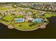 Aerial view showcasing the community clubhouse, pools, manicured lawns, and lakeside setting at 10005 Sage Creek Dr, Ruskin, FL 33573