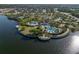 An aerial view of a resort-style community pool, tennis courts, parking, lake, and the surrounding neighborhood at 10005 Sage Creek Dr, Ruskin, FL 33573