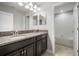 Bathroom featuring a dual sink vanity with granite countertop plus a doorway view to the tub and shower at 10005 Sage Creek Dr, Ruskin, FL 33573