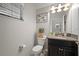 Well-lit powder room featuring granite countertop, dark cabinetry, and decorative wall art at 10005 Sage Creek Dr, Ruskin, FL 33573