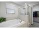 Serene bathroom showcasing a soaking tub, glass-enclosed shower, and natural light with access to closet at 10005 Sage Creek Dr, Ruskin, FL 33573