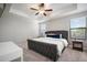 Bright bedroom featuring a large bed, tray ceiling with ceiling fan, and natural light from two windows at 10005 Sage Creek Dr, Ruskin, FL 33573