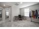 Cozy bonus room with gray walls and carpet plus a desk, chair, and rack for hanging clothes in this home at 10005 Sage Creek Dr, Ruskin, FL 33573