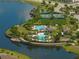 An aerial view of the community pool, clubhouse, and tennis courts along the lake at 10005 Sage Creek Dr, Ruskin, FL 33573