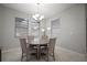 Bright dining room with a round table, chandelier, three windows and neutral decor at 10005 Sage Creek Dr, Ruskin, FL 33573