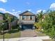 Beautiful two-story home featuring a paved driveway and lush, tropical landscaping at 10005 Sage Creek Dr, Ruskin, FL 33573