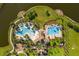 Aerial view of a community pool featuring a pool, splash pad, playground, and picnic area near the lake at 10005 Sage Creek Dr, Ruskin, FL 33573