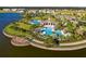 Aerial view of resort style pool and clubhouse surrounded by palm trees with lake view at 10005 Sage Creek Dr, Ruskin, FL 33573