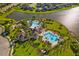 Aerial view of a large resort style pool with multiple features, near a lake at 10005 Sage Creek Dr, Ruskin, FL 33573