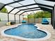Screened-in swimming pool features a brick paver deck with outdoor furniture and view of the backyard at 10005 Sage Creek Dr, Ruskin, FL 33573