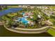 Aerial view of resort style pool and clubhouse surrounded by palm trees with lake view at 10005 Sage Creek Dr, Ruskin, FL 33573
