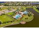 Aerial view of resort style pool and clubhouse surrounded by palm trees with lake view at 10005 Sage Creek Dr, Ruskin, FL 33573