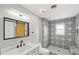 Beautifully renovated bathroom with black and white patterned tiles, a modern vanity, and a barn door mirror at 1002 Fruitland Ave, Bradenton, FL 34207