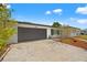 Charming home featuring a driveway, gray garage door and well-maintained landscaping at 1002 Fruitland Ave, Bradenton, FL 34207