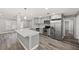 Modern kitchen with stainless steel appliances, gray cabinets, quartz countertop island, and wood-look flooring at 1002 Fruitland Ave, Bradenton, FL 34207