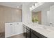 Modern bathroom featuring dual sinks, a large mirror, and a walk-in shower with neutral tile at 1043 Davis Heather Cir, Seffner, FL 33584