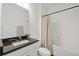 Bathroom featuring a black countertop, white cabinetry, and a shower with a neutral curtain at 1043 Davis Heather Cir, Seffner, FL 33584