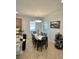 Dining room area with a view of the kitchen, ample seating, and neutral colored walls at 11248 Mollymawk Ct, New Port Richey, FL 34654