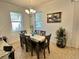 Dining room area featuring six-seater dining table, modern chandelier and natural lighting at 11248 Mollymawk Ct, New Port Richey, FL 34654