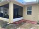 Back exterior view of the home, showcasing the screened-in patio and brick-lined walkway at 11248 Mollymawk Ct, New Port Richey, FL 34654