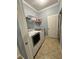 Laundry room with washer, dryer, shelving, and tile flooring at 11248 Mollymawk Ct, New Port Richey, FL 34654