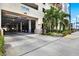 View of the condo complex parking garage with well-manicured landscaping around the entrance, and ocean views nearby at 1238 E Kennedy Blvd # 702, Tampa, FL 33602