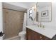 Updated bathroom featuring a tiled shower, wood vanity, and modern gold fixtures at 14007 Middleton Way, Tampa, FL 33624