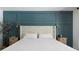 Stylish bedroom featuring a tufted headboard, nightstands, and teal accent wall with decorative molding at 14007 Middleton Way, Tampa, FL 33624