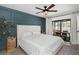 Bright bedroom with a tufted headboard, ceiling fan, and sliding glass doors leading to the patio at 14007 Middleton Way, Tampa, FL 33624
