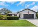 Charming single-story home featuring a well-maintained lawn, grey garage door, and black trim, perfect for suburban living at 14007 Middleton Way, Tampa, FL 33624