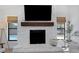 Close up of the living room fireplace, white stone, wood mantle, large flatscreen, and white stone hearth at 14007 Middleton Way, Tampa, FL 33624