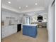Open kitchen layout with white cabinetry, a blue island, and stainless steel appliances at 14007 Middleton Way, Tampa, FL 33624