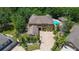 Aerial view of a large home with pool, lush landscaping, brick paver driveway and tile roof at 14809 Ninebark Ct, Land O Lakes, FL 34638