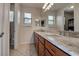 Bathroom with dual sinks, marble countertop, wood cabinets, and tiled flooring and window at 14809 Ninebark Ct, Land O Lakes, FL 34638