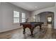 Well-lit game room featuring a pool table, wood floors, and white shutters on the windows at 14809 Ninebark Ct, Land O Lakes, FL 34638