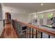 Hallway with wood floors overlooks a great room with soaring ceilings and abundant natural light at 14809 Ninebark Ct, Land O Lakes, FL 34638