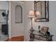 Hallway with hardwood floors, decorator table, lamp, mirror, and arched alcove at 14809 Ninebark Ct, Land O Lakes, FL 34638