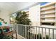 Balcony view showcasing seating, a small table, and lush greenery for relaxed outdoor living at 1500 Gulf Blvd # 103B, Indian Rocks Beach, FL 33785